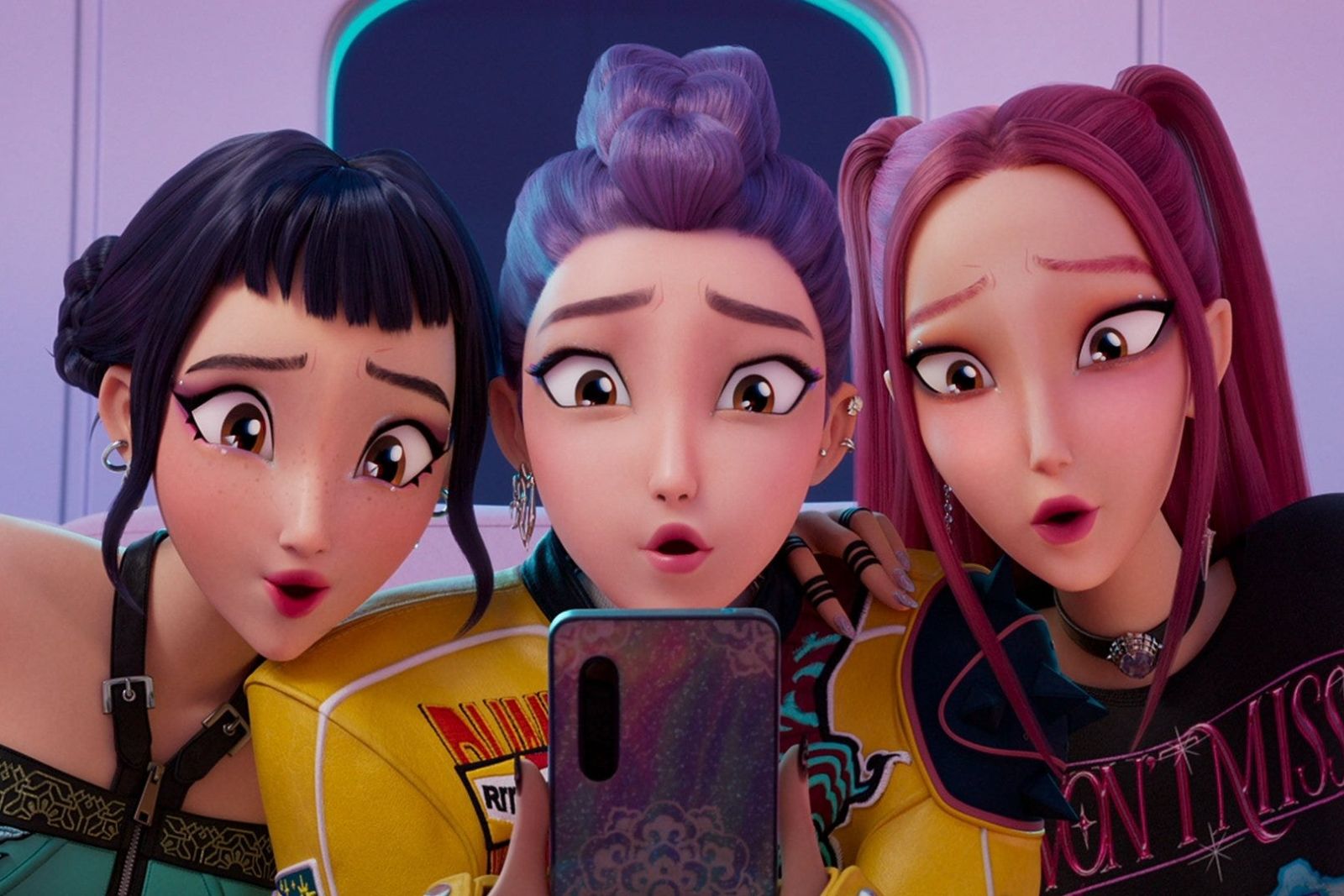 Three animated singers from KPop Demon Hunters, one with black hair, one with a purple braid and one with pink hair, crowding round a phone with wide eyes